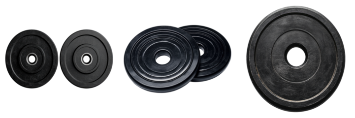 Weight plates arranged for weightlifting exercises to build strength and muscle. The plates are black with various sizes