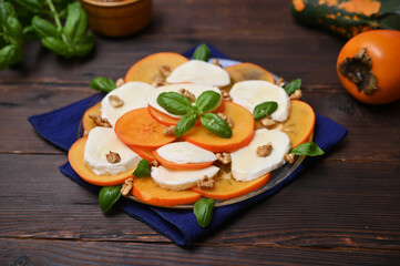 dietary snack of cheese and persimmon on the table close-up
