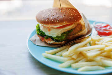 Delicious Cheeseburger with Fries on a Blue Plate