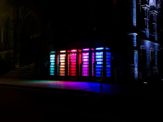 A row of multi-coloured illuminated phone booths in Middlesborough, UK