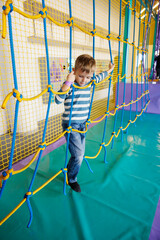 Child Enjoying Rope Climbing Adventure in Indoor Playground