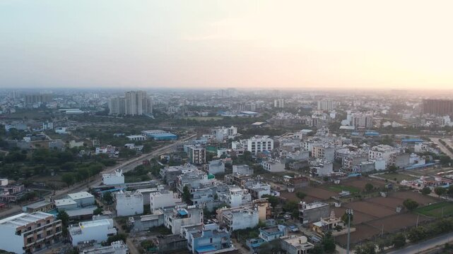 Jaipur aerial drone footage shows urban cityscape, residential buildings, road network, real estate development, mixed infrastructure, highrise structures and expanding metropolitan layout.