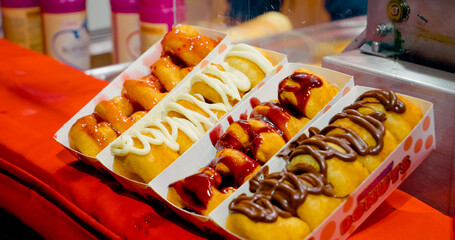 Savor the taste of freshly made donuts filled with sweet jam, beautifully displayed at a bustling Christmas market during the holiday season.