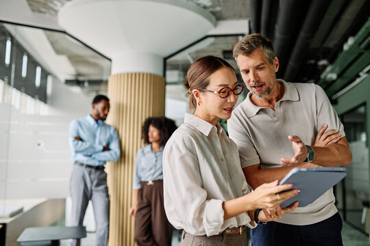 Portrait of young businesswoman and businessman using a tablet having a meeting or presentation and seminar in the office - Powered by Adobe