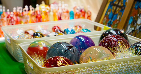 Explore vibrant Christmas balls and unique souvenirs displayed at a bustling Christmas market table, surrounded by the joy of festive gifts and street food.