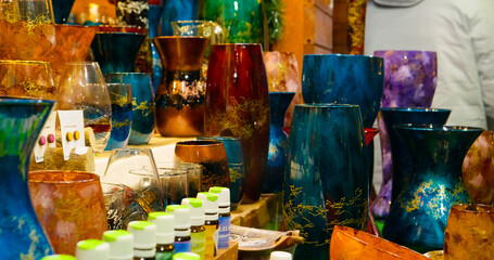 Explore a vibrant Christmas market filled with colorful vases and unique souvenirs. Discover festive gifts, tasty street food, and a joyful holiday atmosphere.