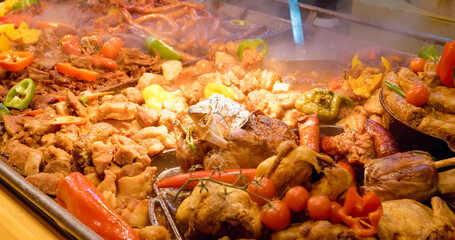 Steaming street food presents roasted pork, sausages and vegetables, creating a culinary delight for food enthusiasts