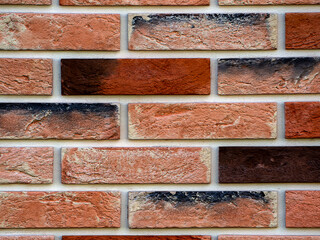 Abstract geometric background. Copy space. Decorative neat masonry made of multicolored bricks. Close-up.
