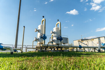 Gas processing facility equipment with pipelines and clear blue sky in rural area during daytime