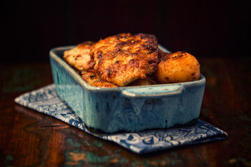 Fried chicken breast with potatoes. Rustic wooden background. Soft focus.	