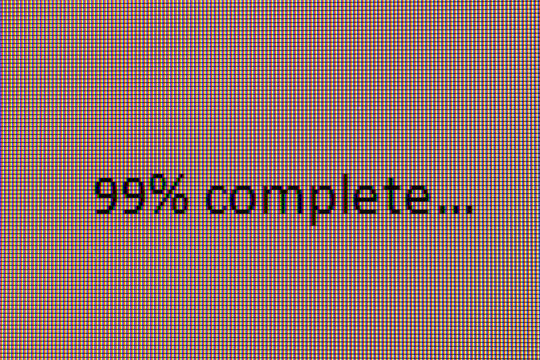 Macro view of a digital screen showing progress bar with  "99% complete..." The image, which highlights RGB sub-pixels, symbolizes delayed progress, anticipation, and the frustration of waiting - Powered by Adobe
