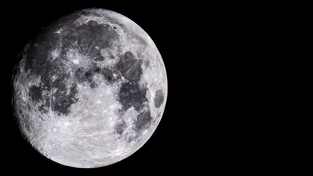 Detailed view of the Moon's surface slowly panning across its craters and lunar maria, revealing the texture of the Earth's natural satellite against the black emptiness of outer space