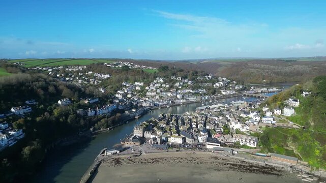 
Looe, Cornwall, England: DRONE VIEWS: The drone flies over the River Looe estuary and Looe beach towards the town. Looe is an ancient fishing port and popular UK holiday destination.