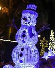 A charming, illuminated snowman made of twinkling lights, standing proudly in a festive display, capturing the joyful spirit of the holiday season with its whimsical design.