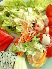 Healthy mixed salad with fresh fruit and white creamy dressing