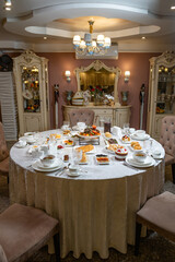 Elegant round banquet table set for luxury breakfast in ornate vintage style dining room