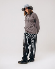 Female hip-hop dancer in gray street style outfit dancing in studio