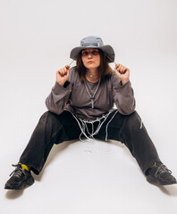 Female hip-hop dancer in gray street style outfit dancing in studio