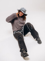 Female hip-hop dancer in gray street style outfit dancing in studio