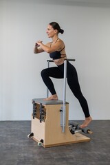 Caucasian woman doing Pilates on classic chair.