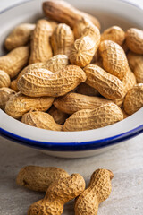 Peanuts in shell. Groundnuts in bowl on kitchen table.