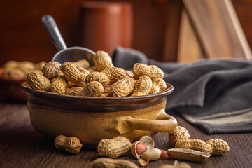 Peanuts in shell. Groundnuts  in bowl on wooden table.