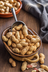 Peanuts in shell. Groundnuts  in bowl on wooden table.