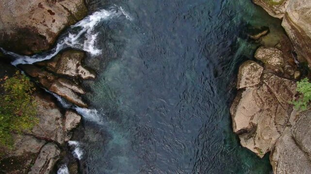 Aerial view of K&ouml;pr&uuml;l&uuml; Canyon: A narrow section of the clear, deep turquoise K&ouml;pr&uuml;&ccedil;ay River, surrounded by moss-covered rocks and small waterfalls.