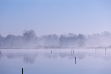 Misty Morning on the Lake with Distant Trees, Poland, Background or Wallpaper