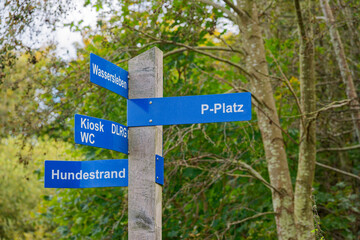 Wooden direction post with walking route arrows for hikers