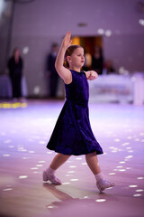 Children compete in ballroom dancing event in a bright venue