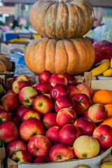 Red Apples with Stacked Pumpkins on Market Stall, Autumn Harvest