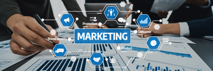 Business analysts collaborate on marketing strategies using charts and visual icons. They focus on consumer engagement, brand identity, and promotional tactics. Amity