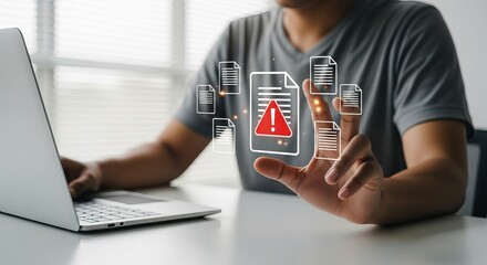 A young Asian male engaged with a laptop, interacting with digital alerts related to documents, conveying a serious mood.