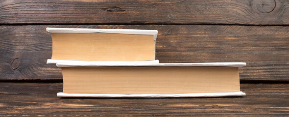 Stack of white books. Education background. Back to school. Book, hardback books on wooden table. Education business concept. Copy space for text. panorama, banner.