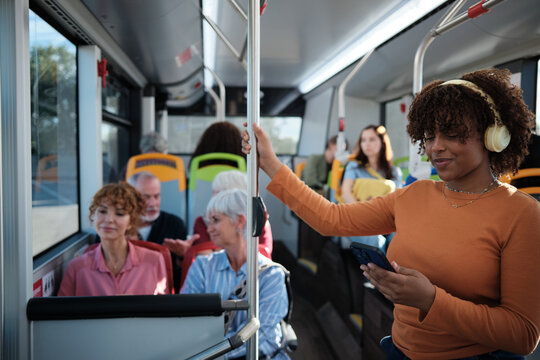 Young woman commuting on bus using smartphone
