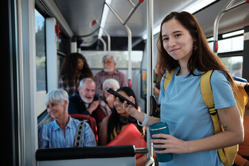 Young woman commuting on public bus using smartphone