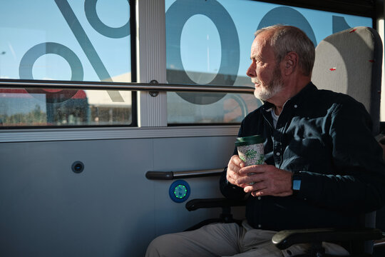 Senior man commuting on bus, looking out window