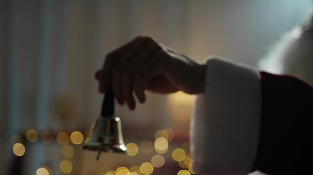 Santa ringing a small bell with his hand 