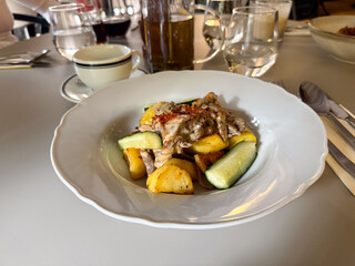 Lunch with roasted potatoes, mushrooms, and sauce. Everyday dining, comfort, and satisfaction captured in warm tones and gentle light.