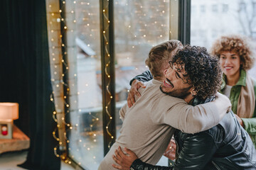 Meeting of two friends indoor hugging near the door
