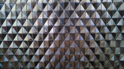 Geometric metallic triangles pattern creating a reflective surface.