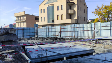 Urban construction site with barricades and building in background.