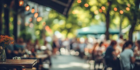 Blurred outdoor restaurant scene with people and string lights.