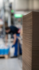 Stack of corrugated cardboard sheets in industrial packaging facility
