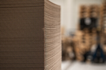 Stack of corrugated cardboard sheets in industrial packaging facility
