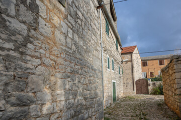 Charming Village Street With Stone Buildings Under Cloudy Sky, Grohote, Croatia