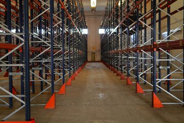 A pallet racking storage system in a warehouse. The industrial shelving is empty. The bright and...