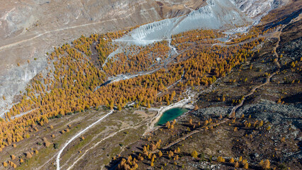 A drone view above Zermatt reveals the stunning Matterhorn region with its famous lakes, golden larches, and a deep blue autumn sky in perfect harmony.