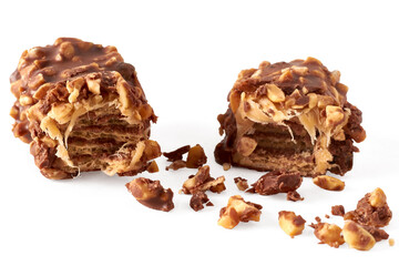 Close-up of a broken wafer caramel bar with nuts in chocolate glaze on a white background/